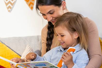 Mutter schaut mit Kind tiptoi Buch an