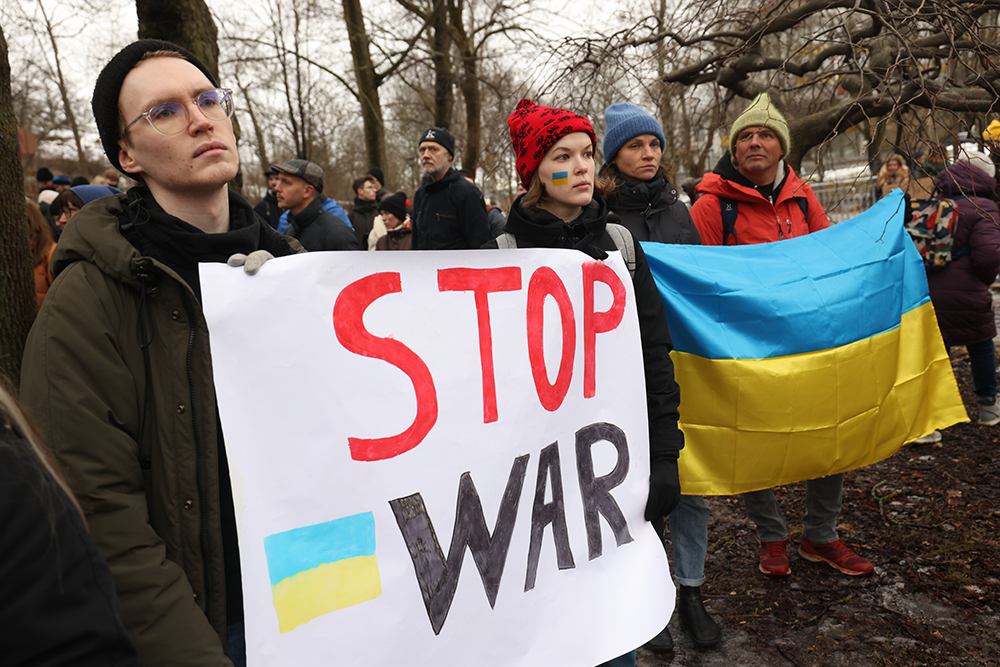 Demonstranter mot krigen i Ukraina holder et skilt med teksten "stop war". Bilde