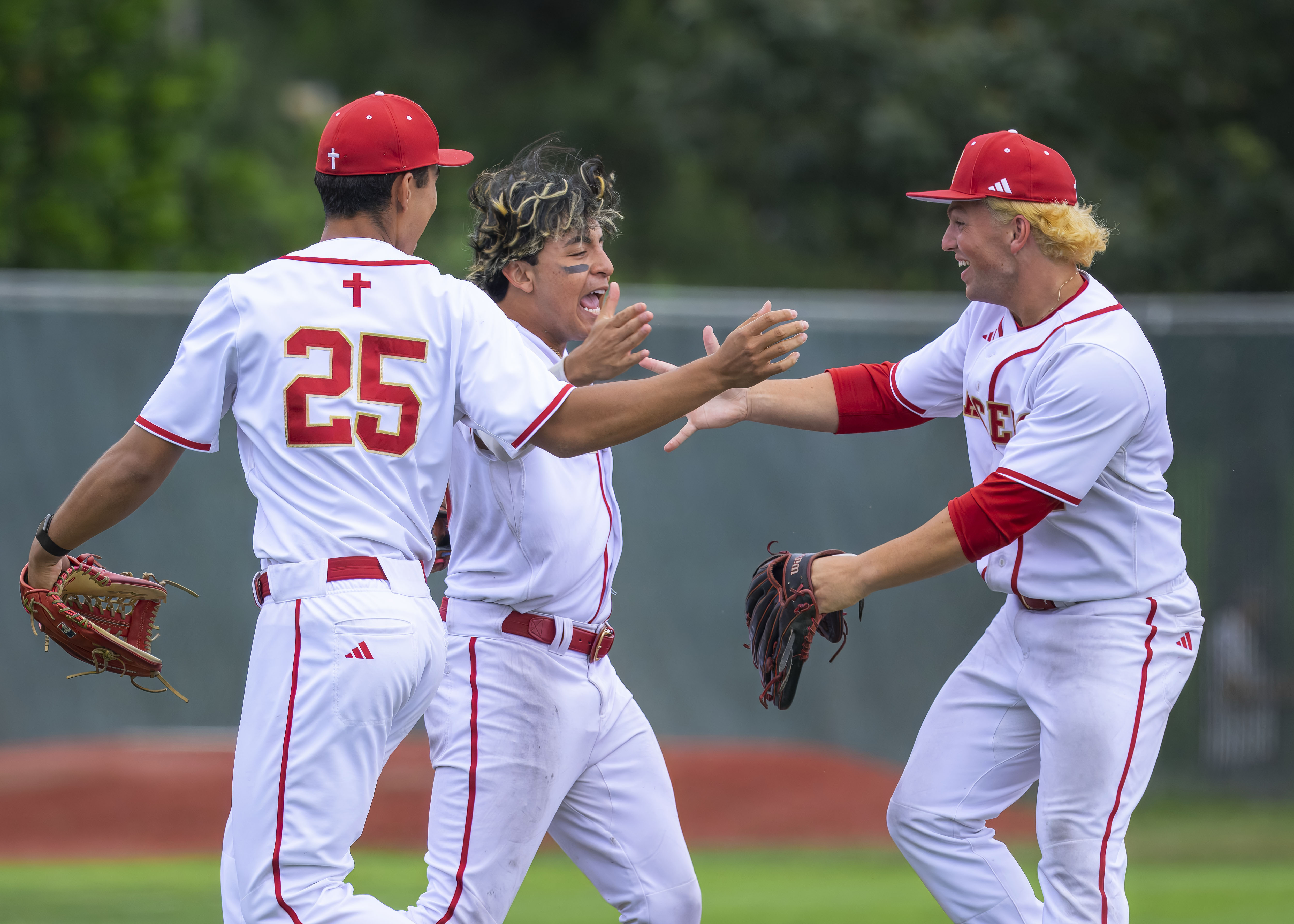 Orange Lutheran’s Eric Zdunek, Ricardo Hurtado, and Hamilton Friedberg, from left, celebrate winning the first round of the CIF-SS Division 1 baseball playoffs against Santiago of Corona in Orange on Tuesday, May 12, 2026. (Photo by Paul Rodriguez, Contributing Photographer)
