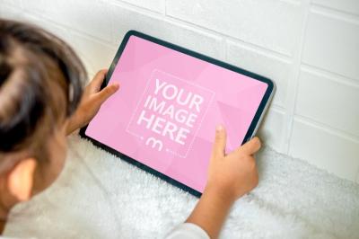 Mockup of an iPad Featuring a Kid Browsing on It
