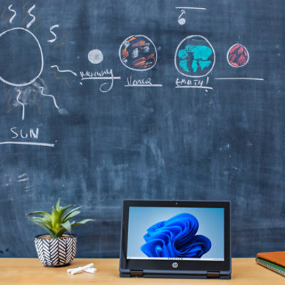 Un laptop pe o masă, afișând un obiect albastru cu textul „PĂMÂNT” și „SOARE”.