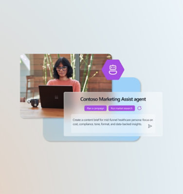 Seorang laki-laki yang mengenakan setelan jas duduk dengan laptop di meja 