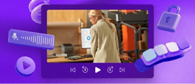 一頭金髮的人正在看著裝滿辦公設備桌子上的顯示器。