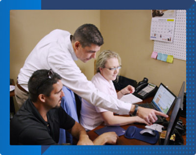 Un grup de persoane uitându-se la un ecran de computer.