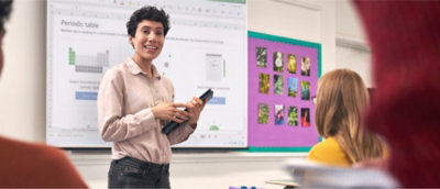 Uma pessoa a segurar um tablet à frente de um quadro.