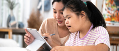 O femeie și un copil care se uită la o tabletă.