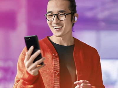 seseorang menatap perangkat seluler sambil tersenyum