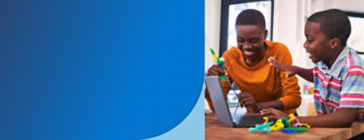 Two boys playing with a laptop infront.