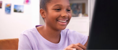 Pessoa de t-shirt roxa sentada num sofá com um portátil, a participar numa conversa ou atividade.