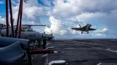 An F/A-18F Super Hornet, assigned to Strike Fighter Squadron (VFA) 41, prepares to make an arrested landing on the flight deck of the U.S. Navy Nimitz-class aircraft carrier USS Abraham Lincoln in the Pacific Ocean August 10, 2024. U.S.