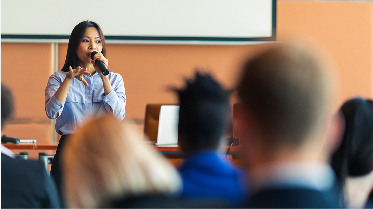 Young professional woman presenting at an event.