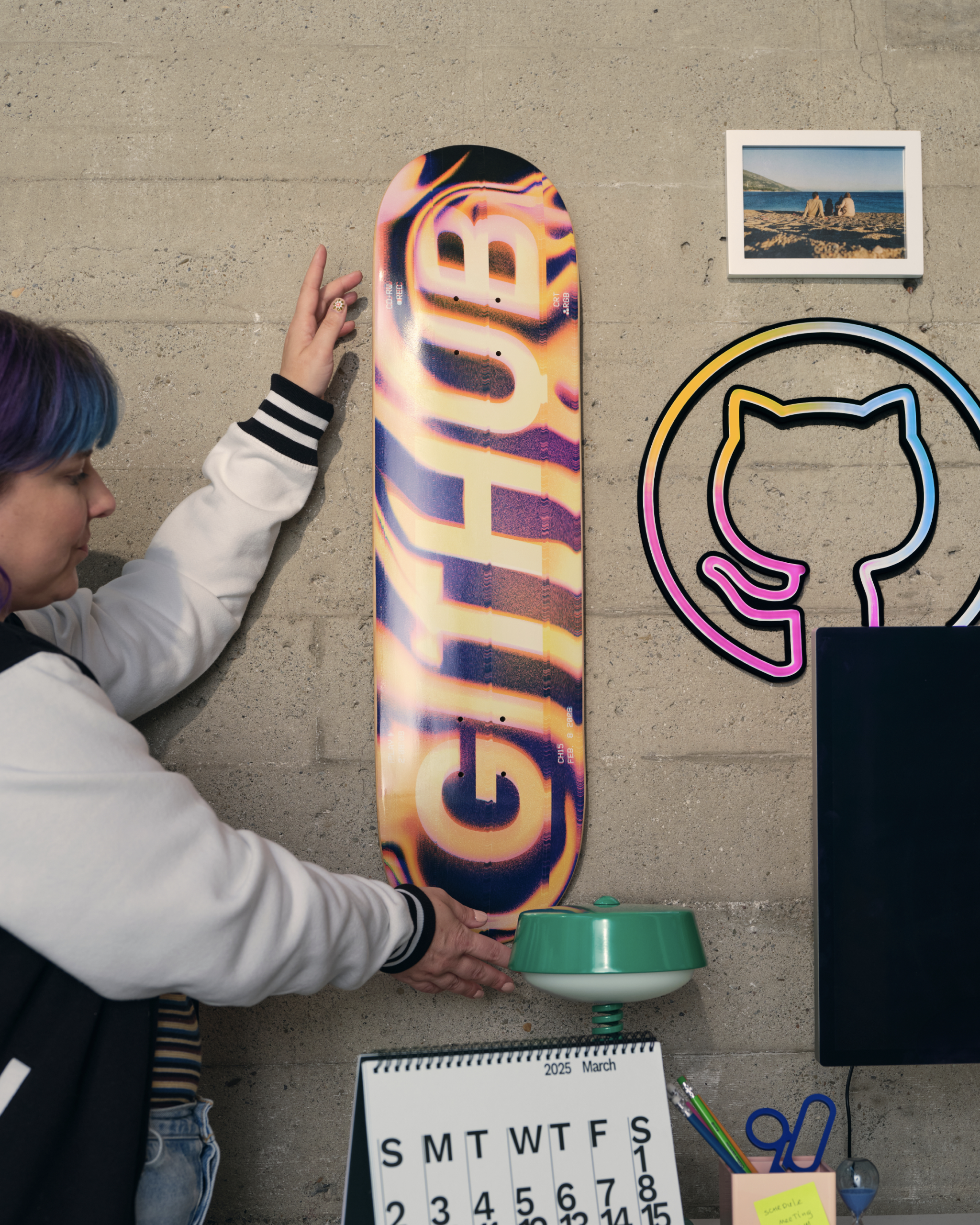 woman placing GitHub Skateboard on wall.