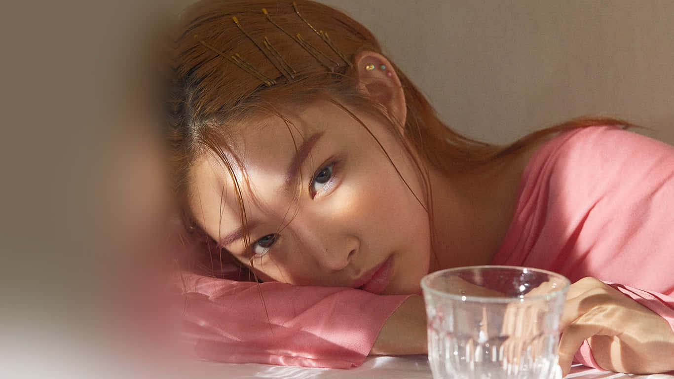 Contemplative Asian Man Leaning on a Table Wallpaper