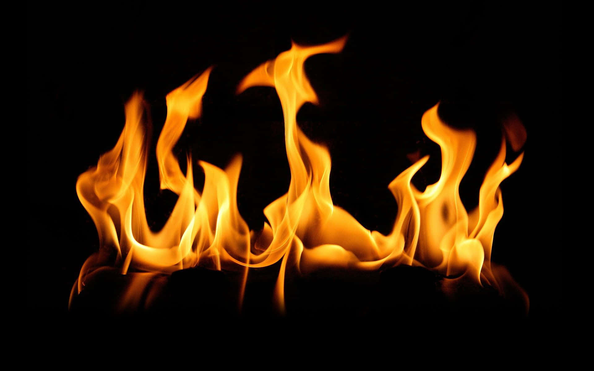 a black background with flames on it Wallpaper