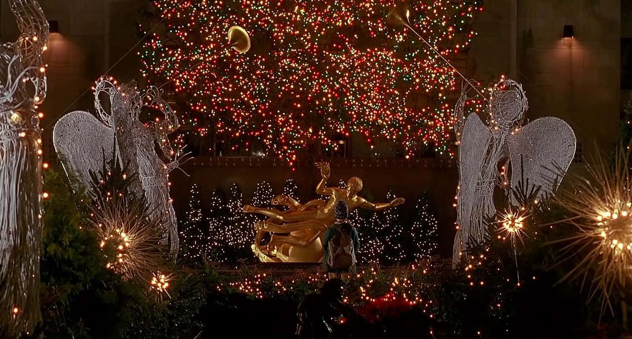 A Christmas Tree With Angels And Lights In Front Of It