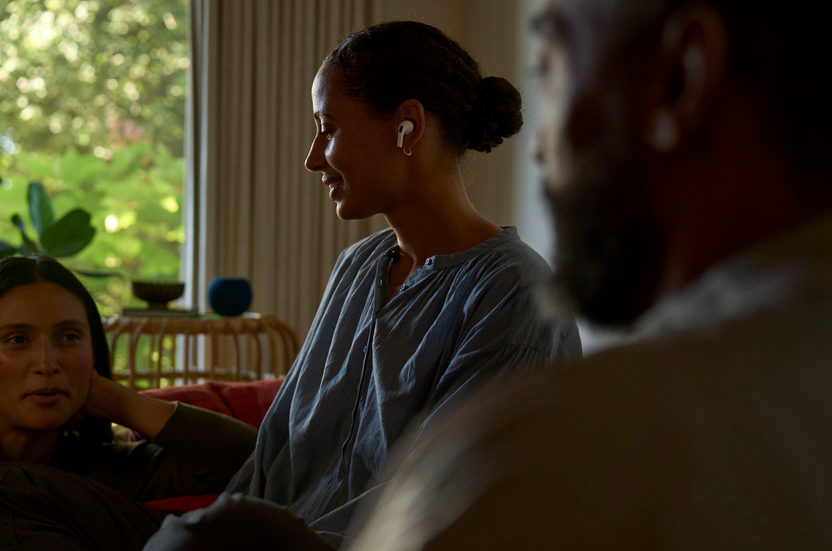 Foto de perfil de una mujer con unos AirPods Pro 2 en la oreja izquierda y usando las funcionalidades de Salud Auditiva