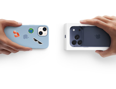 Inruilartikel dat overgaat van de ene in de andere hand. iPhone 13 in een siliconenhoesje met stickers op de achterkant, die wordt ingeruild voor een nieuwe iPhone 17 in de verpakking.